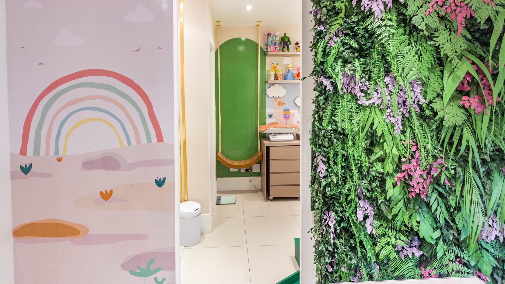 Ambientes do consultório: parede com arco-íris, sala infantil e parede de plantas