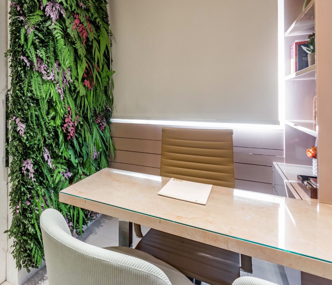 Mesa de atendimento, com parede de plantas ao lado