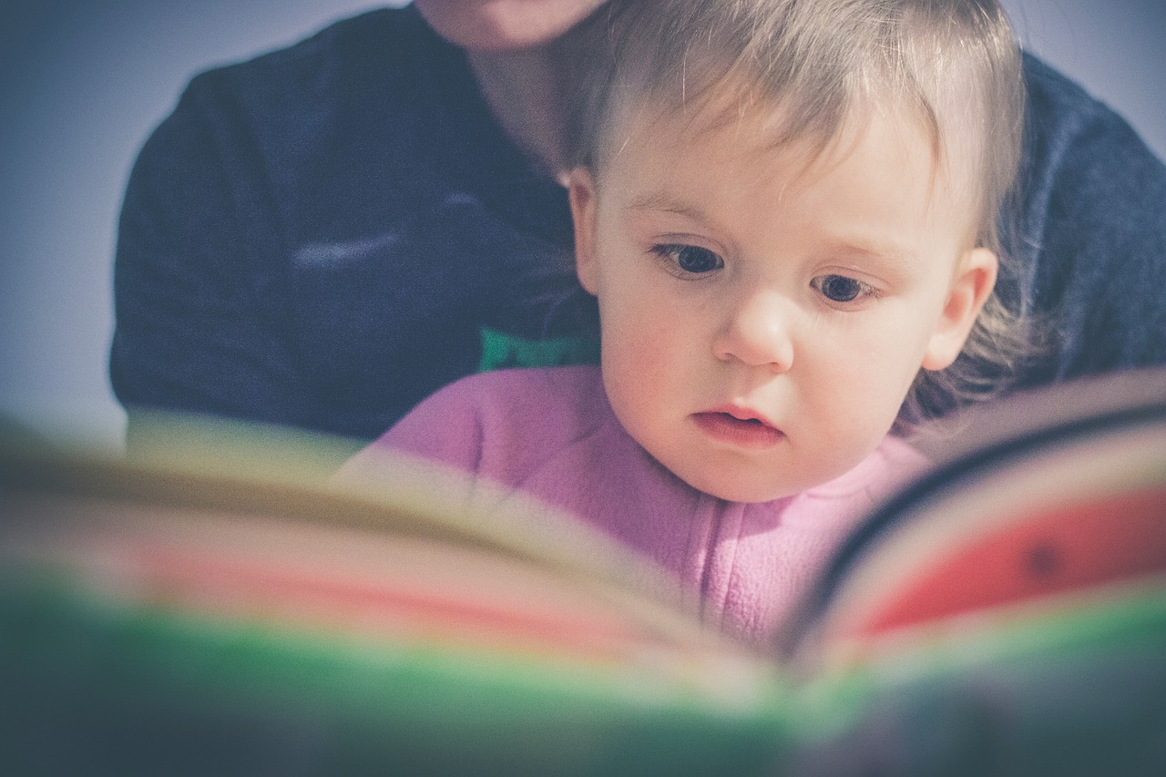 Bebe curioso olhando um livro, tema mitos e verdades sobre alergia infantil