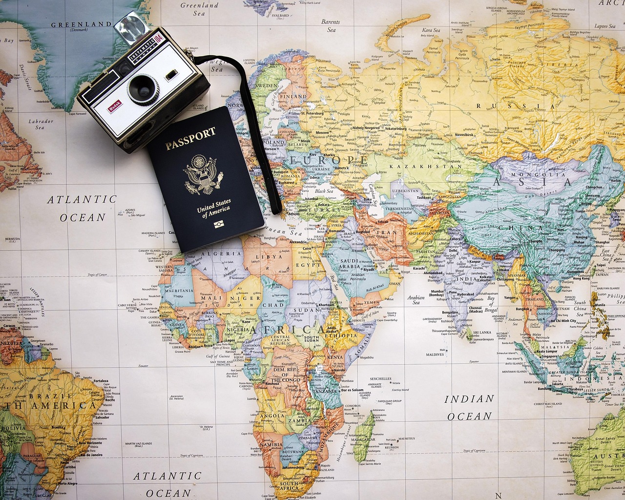 Passaporte sobre um mapa-múndi, ilustrando o artigo sobre vacina de febre amarela para viagem internacional e alergia
