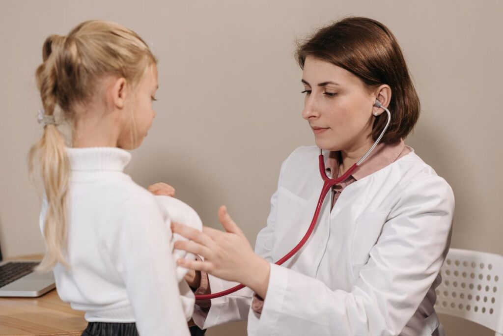 Pediatra examinando criança com estetoscópio, ilustrando o artigo sobre urticária infantil